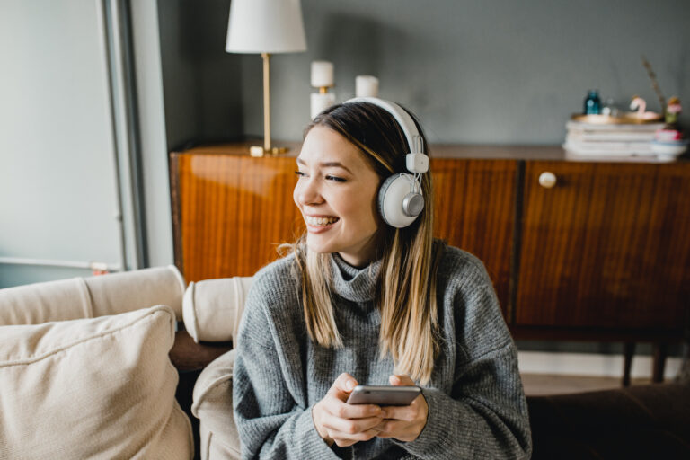 Happy smiling woman with headphones and a phone